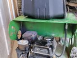 a green machine with a black tank sitting on top of it