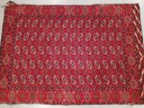 a red rug with a pattern on it on a white surface