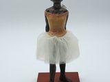statue d'une femme en tutu posée sur un socle en bois