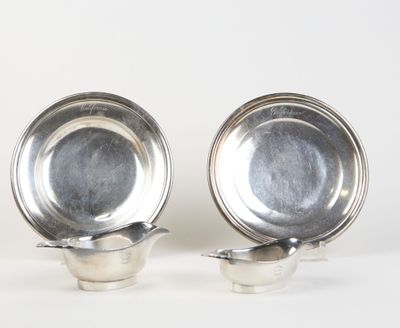 pair of silverplated dishes on stands on a white surface