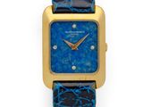 une montre dorée et bleue avec un bracelet en cuir