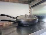 pots and pans sit on a stainless steel counter in a commercial kitchen