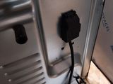 a silver refrigerator with a power cord plugged into it