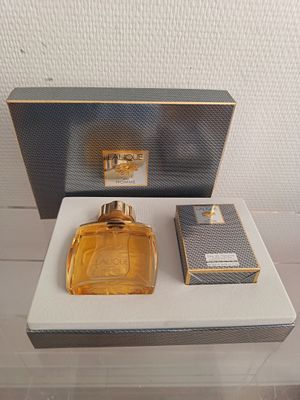 un flacon de parfum posé sur une table à côté d'une boîte