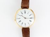 une image représentant une montre-bracelet en or avec des chiffres romains sur fond blanc
