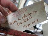 a hand holding a piece of paper with writing on it