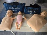 three mannequins on a table with a bag and a bag behind them