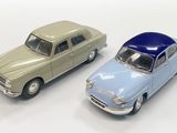 two toy cars sitting next to each other on a white surface