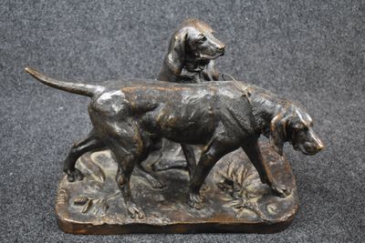 bronze statue of a dog and a cat on a rock