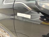 a man that is standing next to a car with a sticker on it