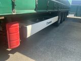 a large green truck with a red container underneath it