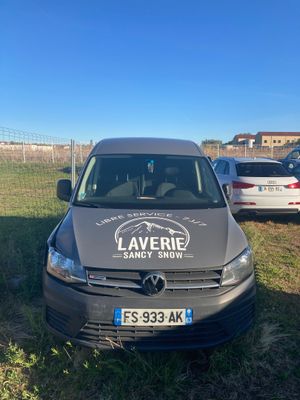 La camionnette est garée sur l'herbe, devant une clôture.