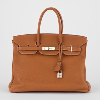un sac à main en cuir marron muni d'un cadenas sur la poignée