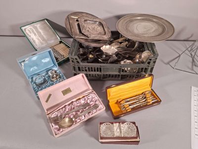des couverts et d'autres objets en argent dans une boîte posée sur une table