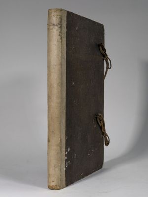 un vieux livre à la couverture marron posé sur une table blanche