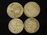 four different types of gold coins on a black background