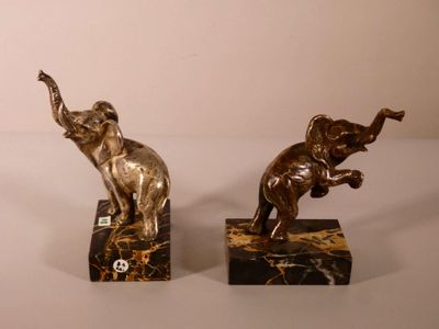 deux statues d'éléphants posées sur des blocs de marbre, sur une table