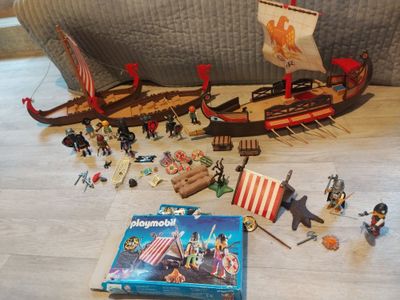beaucoup de jouets par terre, à côté d'un livre