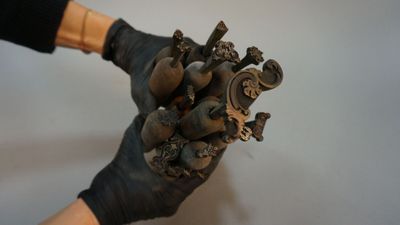 a person wearing black gloves holding a statue of a heart