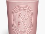 un gros plan d'une bougie rose sur fond blanc