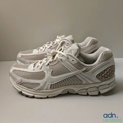 the shoe is white and has a mesh design on the sole