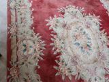 a red area rug with a floral design on it