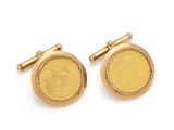 a close up of a pair of gold cufflinks on a white background