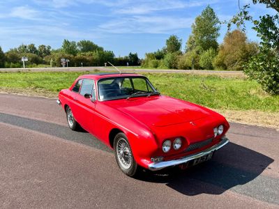 une voiture rouge garée sur le bord de la route
