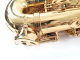 a gold saxophone sitting on top of a white table