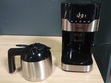 a coffee maker sitting on a counter next to a coffee pot