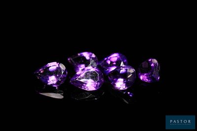 a close up of a group of purple gems on a black surface