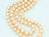 a close up of a strand of pearls on a white surface
