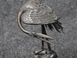 un gros plan sur la statue d'un oiseau posé sur un rocher