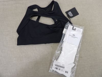 Le haut d'un soutien-gorge de sport noir se trouve à côté d'un colis emballé