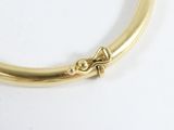 an image of a close up of a gold bracelet on a white surface