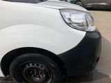 a white van with black rims parked in a parking lot