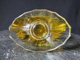 a yellow glass object on a rock on a black background