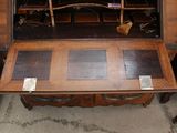 a small wooden desk with a mirror on top of it
