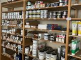 many shelves of paint and other paints in this room