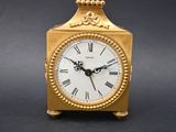 an image of a gold clock with roman numerals on the face