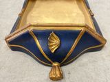 a blue and gold box with a gold leaf on it