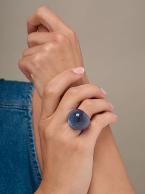 une personne portant une bague sertie d'une pierre bleue