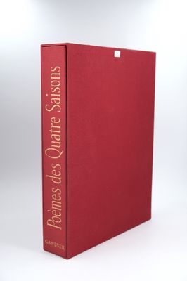a red book sitting on top of a white table next to a lamp