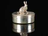a silver rabbit sitting on top of a silver box