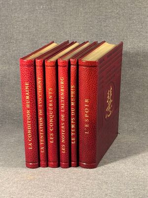 four red books sitting on top of each other on a table