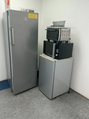 a silver refrigerator and a black and white machine in a room