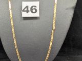 un gros plan d'un collier porté par un mannequin, sur lequel figure le chiffre 46