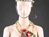 une image représentant un mannequin portant une coiffe faite de perles et de plumes