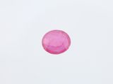 gros plan d'une pierre rose sur une surface blanche