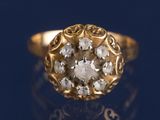 une bague en or sertie d'un diamant, posée sur un fond bleu
